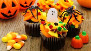 Halloween cupcakes and candy on wooden table | 15 Halloween Treat Ideas For Your Sweet Tooth | featured