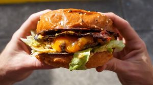 reZbnolscDo-person holding cheese burger-copycat recipes-us-feature