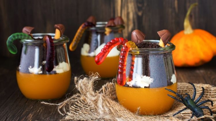 Layered halloween trifle with pumpkin jello, worms and toadstools on autumn background | Jello Worms in Dirt: A Creepy Crawly Halloween Dessert! | Featured