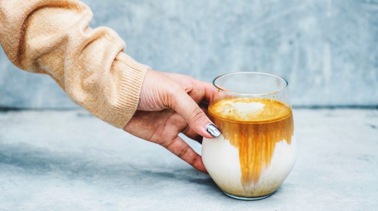 person holding clear drinking glass-homemade pumpkin spice latte-px-feature