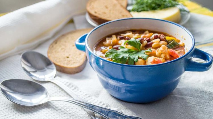 bowl of soup and two silver spoons | Vegan Soups You Need To Master This Winter | Featured