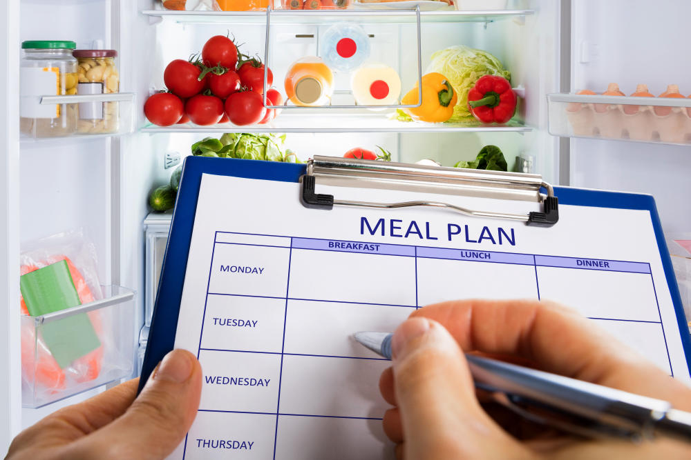 Person's Hand Filling Meal Plan Form On Clipboard | How To Meal Prep (Beginner's Guide 2020) | how to meal prep reddit