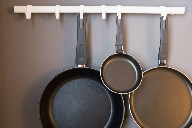 different sizes of pans hanging on the wall | How To Fry Food Without Oil Splatter | frying food