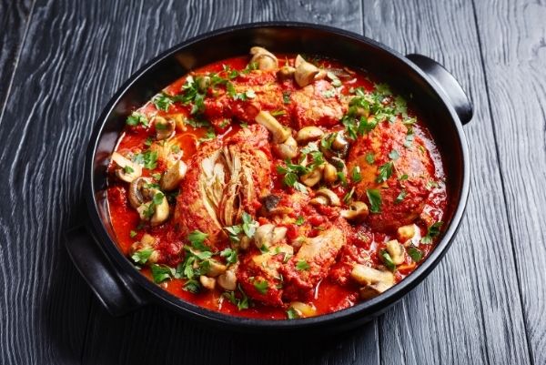 Chicken Cacciatore with tender chicken breasts, tomatoes, bell peppers, carrots and sliced mushrooms in a black ceramic dish | healthy crockpot recipes