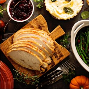 Sliced roasted tukey breast for Thanksgiving or Christmas dinner with side dishes overhead shot | Juicy and Tender Air Fryer Turkey Breast | Featured